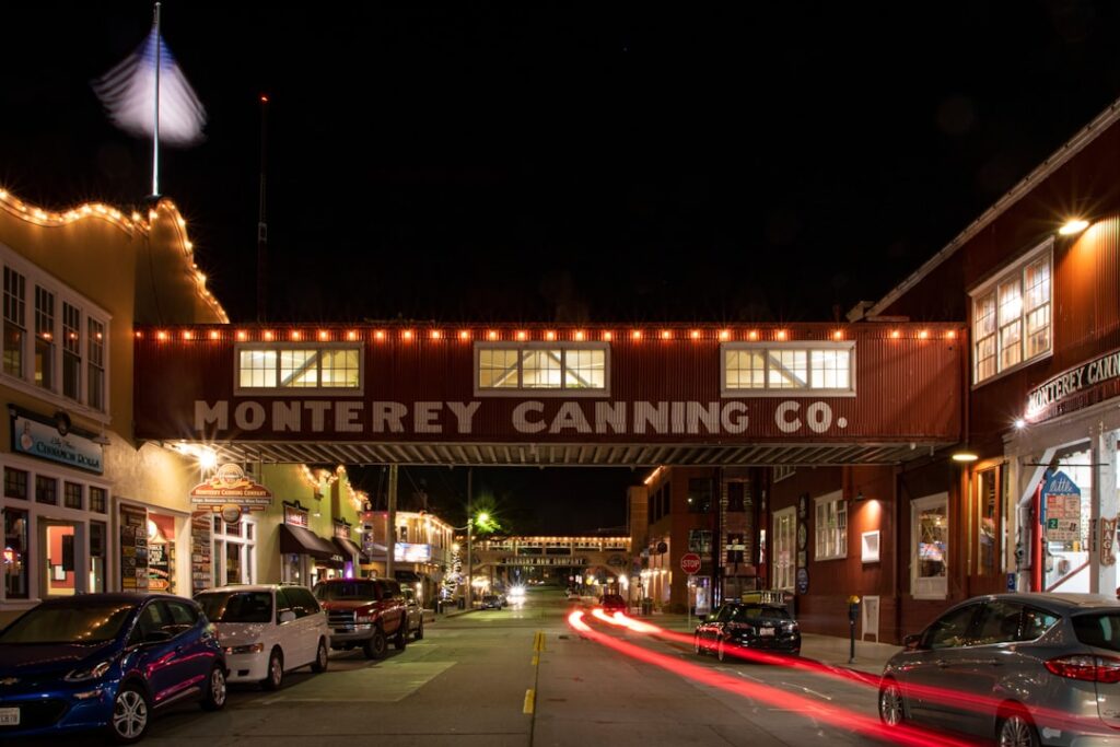 a city street at night with cars passing under a bridge