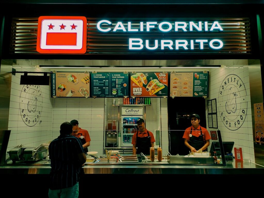 A couple of people standing in front of a restaurant